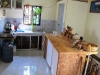 en rechts is er de keuken met rechtsachter een losse badkamer en op de voorgrond een zelfgetimmerd keukenblok
